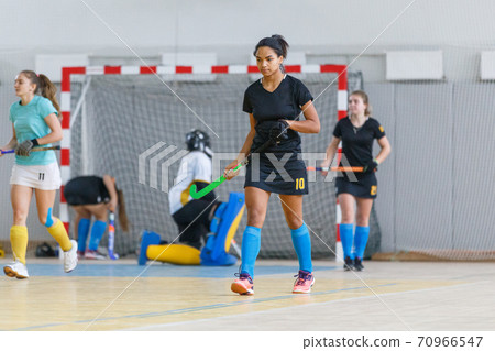 Indoor hockey female player returning after attack Indoor hockey female player returning after attack 70966547