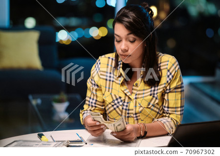 Latin American Woman Doing Home Budget And Counting Money Latin American Woman Doing Home Budget And Counting Money 70967302