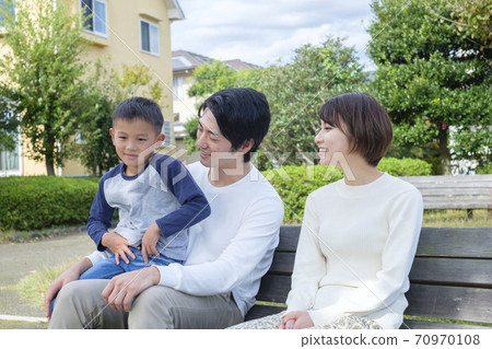 Couple and boys relaxing on a park bench Couple and boys relaxing on a park bench 70970108