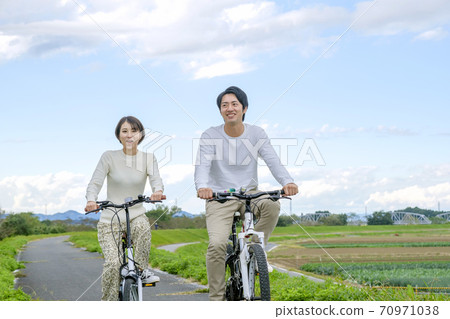 Men and women cycling Men and women cycling 70971038