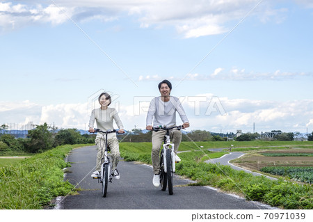 Men and women cycling Men and women cycling 70971039