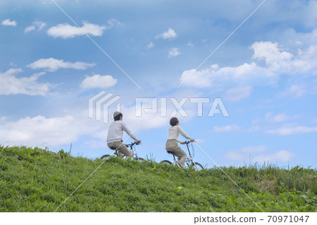 Men and women cycling Men and women cycling 70971047