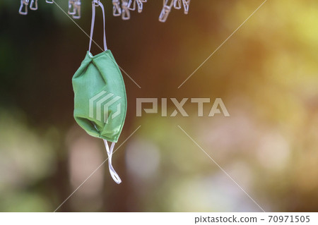 Drying mask hanging under the sun after use for disinfecting. Drying mask hanging under the sun after use for disinfecting. 70971505