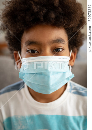 Portrait of boy wearing face mask at home Portrait of boy wearing face mask at home 70975282