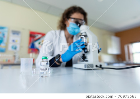 Vial bottle with Covid-19 text on table in laboratory Vial bottle with Covid-19 text on table in laboratory 70975565