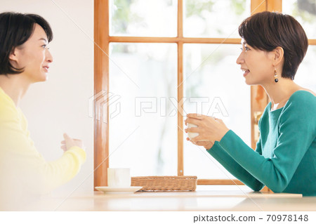 一個女人和一個朋友在一家咖啡館聊天 70978148