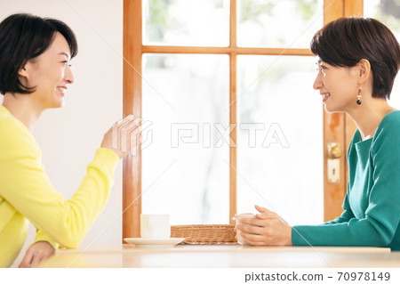 A woman talking with a friend at a cafe 70978149
