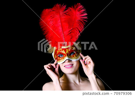 Portrait of a woman in a carnival mask with large bird feathers Portrait of a woman in a carnival mask with large bird feathers 70979306
