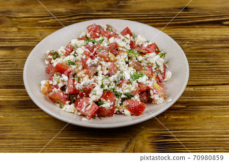 Tasty salad of tomato, cottage cheese, dill and olive oil on wooden table 70980859