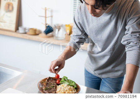 服務在家烹調的一個年輕人在家 服務在家烹調的一個年輕人在家 70981194