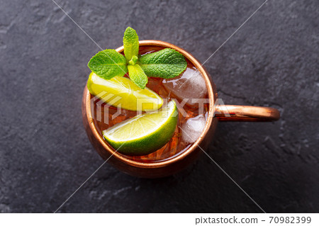 Moscow Mules cocktail with ginger beer, vodka, lime and mint. Grey background. Close up. Top view. 70982399