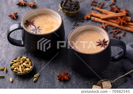 Indian masala tea with milk and spices in mug. Grey background. Close up. 70982545