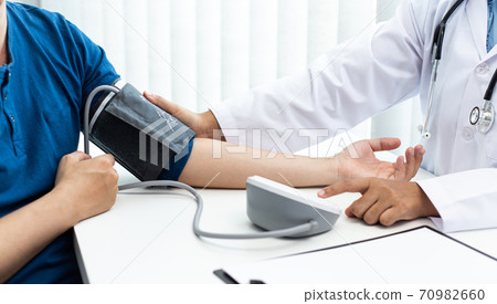 Female doctors use blood pressure monitors and stethoscope to measure pulse Diagnose the patient's disease in a modern hospital medical laboratory, Medical treatment and health care concept. 70982660