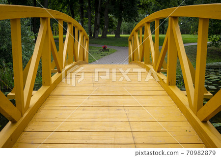 Empty arched wooden pedestrian bridge 70982879