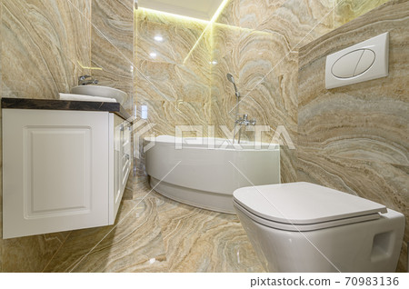 Luxury bathroom with white bathub and beige marble tiles 70983136