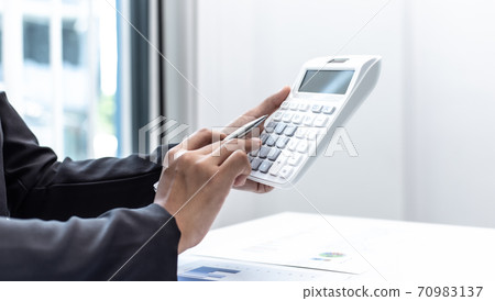 Businesswomen are calculating finances and analyzing market data with graphs and laptops at work, Business Financing Accounting Banking and tax system Concept. 70983137