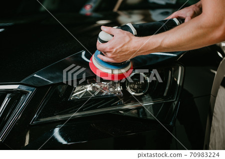 Close up of car detailist hands, cleaning or pilishing the car by poliermaschine, car detailing concept 70983224