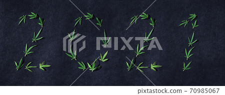 Pattern of cannabis leaves in the form of numbers 2021 on a dark background. The concept of a new year. Cannabis plant background. Copy space. The concept of marijuana love 70985067
