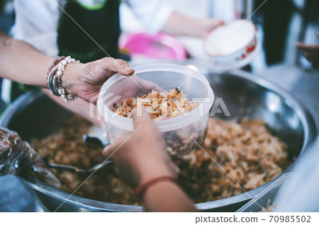 The hands of the poor have been begging to donate food from the donor, The concept of feeding 70985502