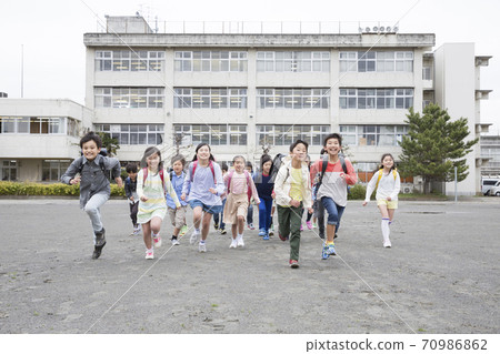 Elementary school students running in the schoolyard 70986862
