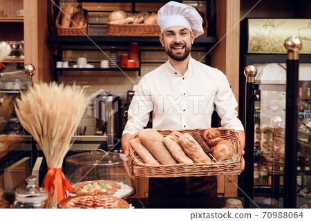 Young Bearded Man in White Cap Standing in Bakery. 70988064