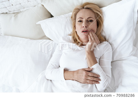 Top view of a woman who holds a bad tooth. Top view of a woman who holds a bad tooth. 70988286