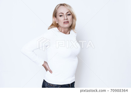 Woman on a white background suffers from back pain Woman on a white background suffers from back pain 70988364