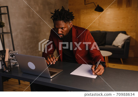 black business man working on laptop and taking notes black business man working on laptop and taking notes 70988634