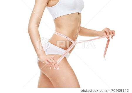 Slim tanned woman's body isolated on white background - waist measurement 70989142