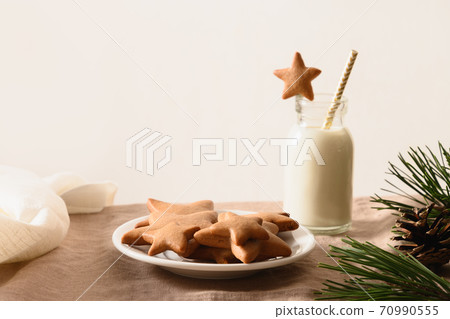 Glass of milk and homemade cookie in home. Glass of milk and homemade cookie in home. 70990555