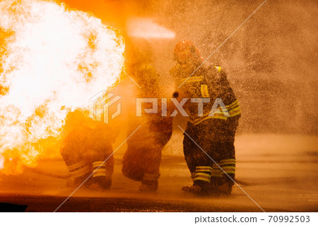 Firefighter training. fireman using water and extinguisher 70992503