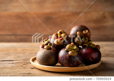 Fresh ripe mangosteen fruits on wooden plate.queen of fruit in Thailand Fresh ripe mangosteen fruits on wooden plate.queen of fruit in Thailand 70993024