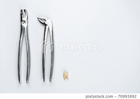 Image of two dental forceps with tooth on isolated white background Image of two dental forceps with tooth on isolated white background 70993892