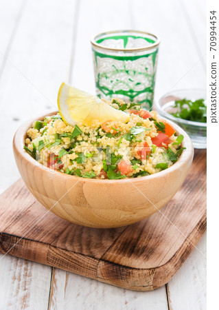 Tabbouleh salad with couscous on white wooden table Tabbouleh salad with couscous on white wooden table 70994454