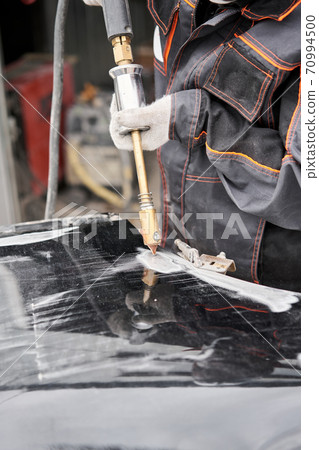 Spotter, a Welding machine for straightening dents on the car body. spot welding of metal. Repair service worker fix damaged car. 70994500