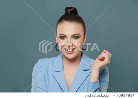 Successful woman smiling on blue background 70994984