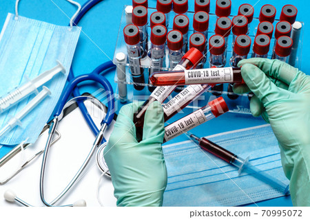 lab technician assistant or doctor holding a blood sample in test tube 70995072