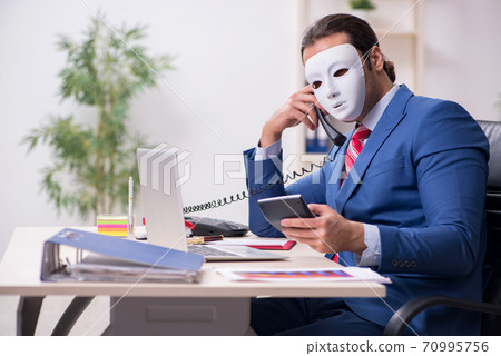 Male employee with mask in hipocrisy concept 70995756