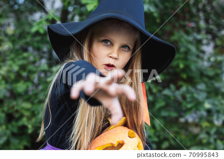 Little girl in witch costume having fun on Halloween trick or treat Little girl in witch costume having fun on Halloween trick or treat 70995843