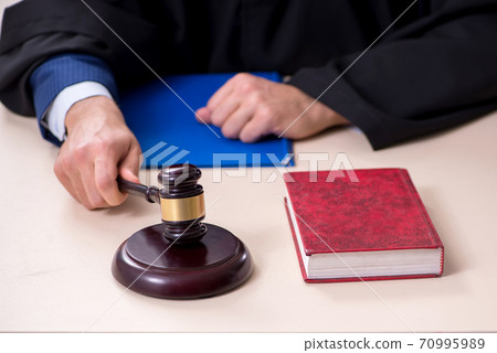 Young male judge working in courthouse 70995989