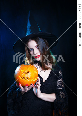 Happy Halloween . Halloween witch with a magic pumpkin on black background. Happy Halloween . Halloween witch with a magic pumpkin on black background. 70996131