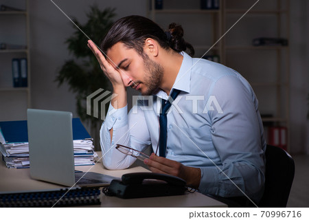 Young businessman working late in the office 70996716