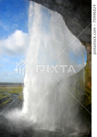Seljalandsfoss Waterfall in Iceland. A famous waterfall with a path to walk behind the falls. Seljalandsfoss Waterfall in Iceland. A famous waterfall with a path to walk behind the falls. 70996824