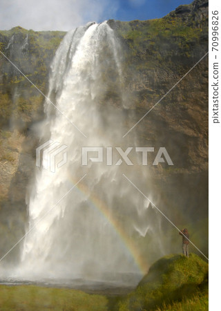 Seljalandsfoss Waterfall in Iceland. A famous waterfall with a path to walk behind the falls. Seljalandsfoss Waterfall in Iceland. A famous waterfall with a path to walk behind the falls. 70996826
