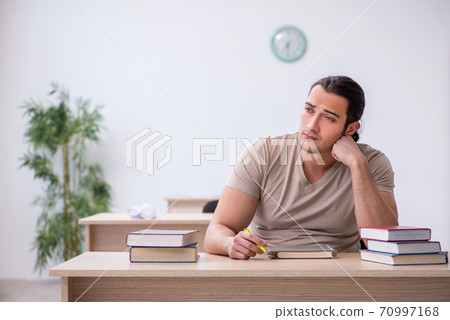 Young male student preparing for exams at library Young male student preparing for exams at library 70997168