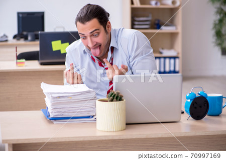 Young male employee in time management concept Young male employee in time management concept 70997169