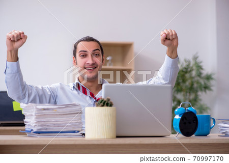 Young male employee in time management concept Young male employee in time management concept 70997170