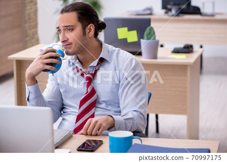 Young male employee in time management concept Young male employee in time management concept 70997175