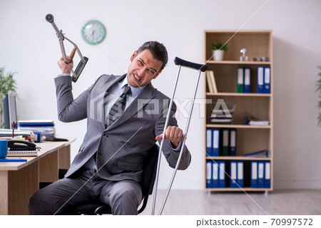 Young leg injured male employee working in the office 70997572