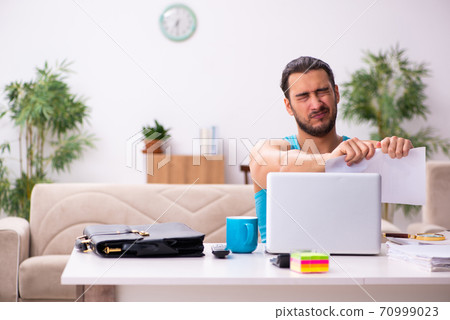 Young man working from house during pandemic Young man working from house during pandemic 70999023